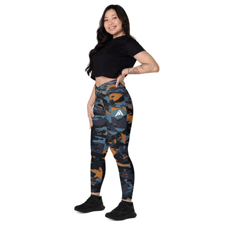 collant sport femme avec des poches latérales couleur camouflage gris-orange physique affûté pose côté gauche